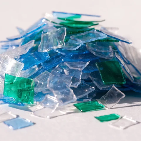 Flocos de PET reciclado triturado em tons transparentes, azuis e verdes
